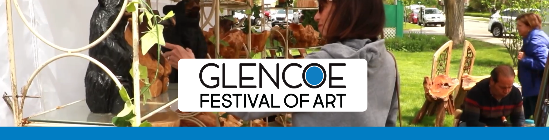 People browsing wooden art sculptures at Glencoe Festival of Art outdoor event