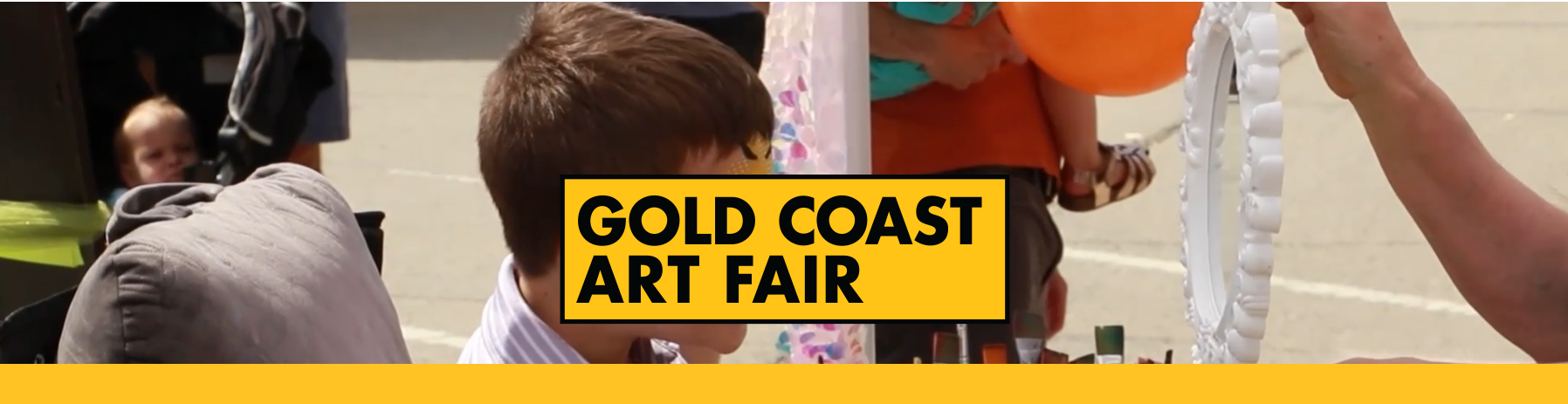 Gold Coast Art Fair outdoor scene with visitors, crafts, child holding balloon, event banner